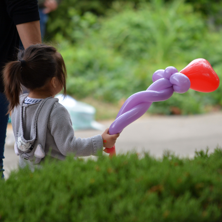 small girl with balloon in garden